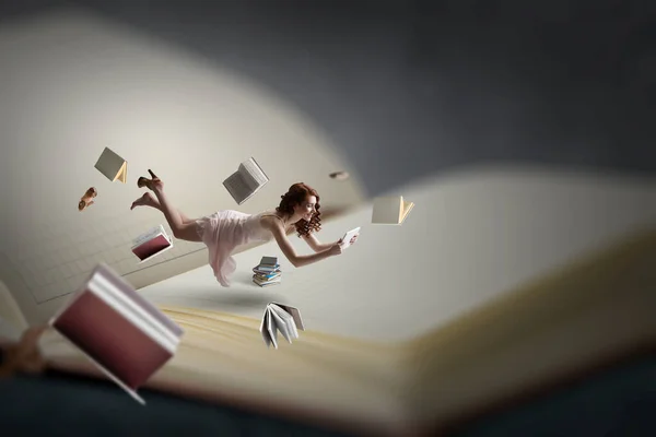 Young woman levitates while reading a book — Stock Photo, Image