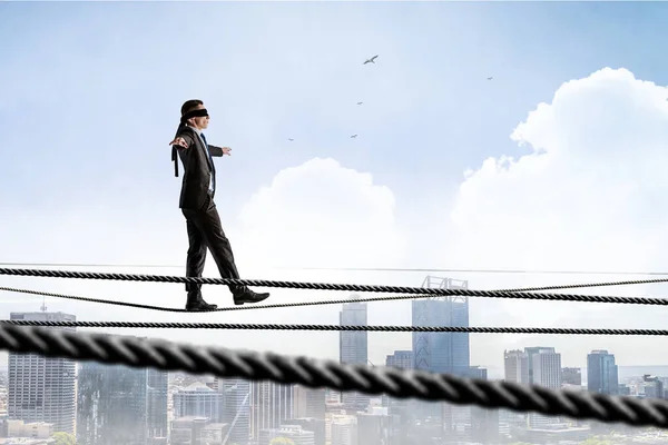Egy kép egy üzletemberről, aki kötélen egyensúlyozik. Kockázati koncepció — Stock Fotó