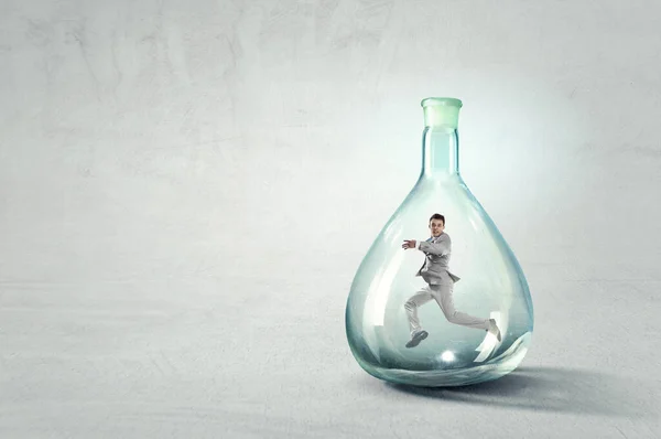 Jovem empresário dançando dentro de garrafa de vidro — Fotografia de Stock