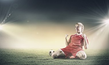 dizlerinin üzerinde duran futbolcu