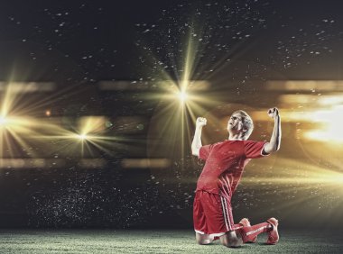 dizlerinin üzerinde duran futbolcu