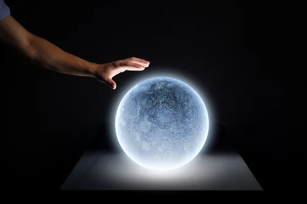 Mano humana tocando la luna azul brillante —  Fotos de Stock