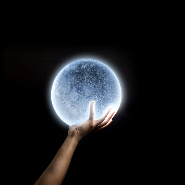 Человеческая рука держит голубую светящуюся луну — стоковое фото