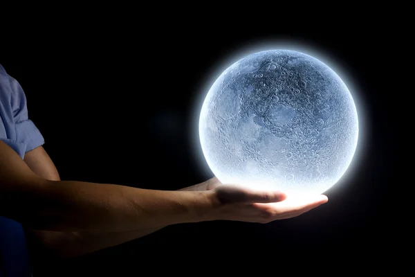 Mano humana sosteniendo la luna azul brillante — Foto de Stock