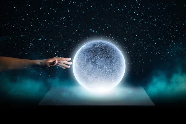 Menschliche Hand berührt blau glühenden Mond — Stockfoto