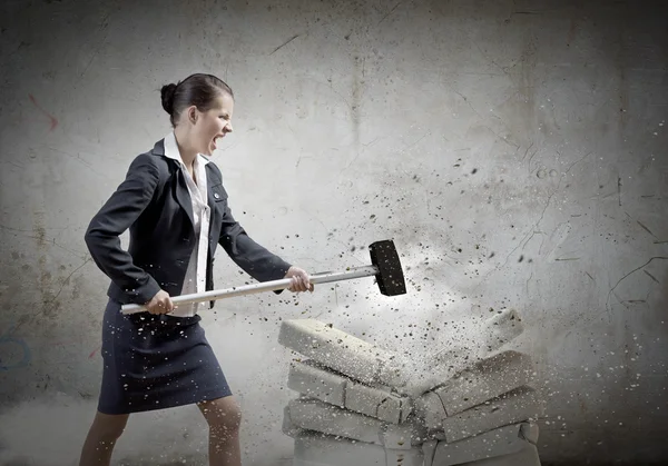 Businesswoman crashing bricks — Stock Photo, Image