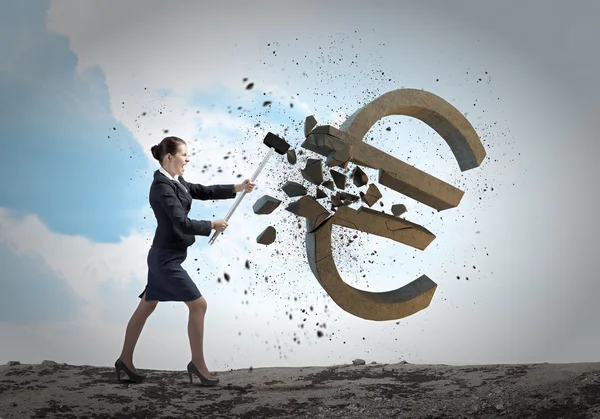 Businesswoman crashing stone euro symbol — Stock Photo, Image