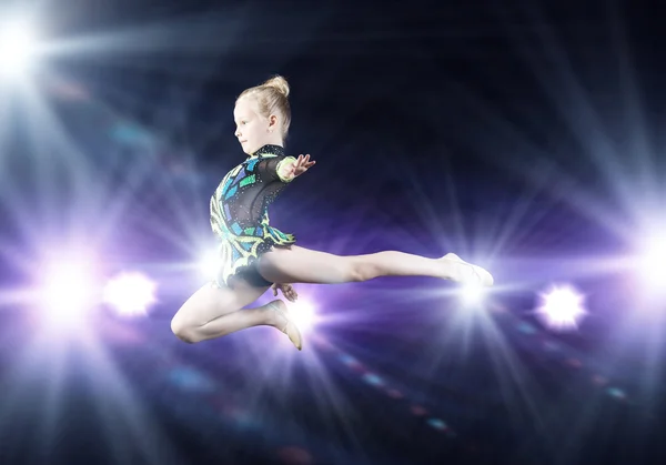 Дівчина гімнастка стрибає високо — стокове фото