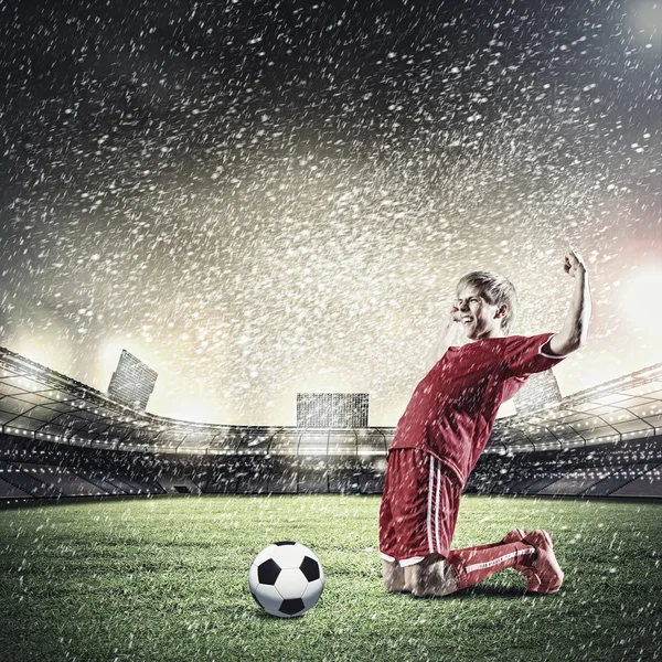 Jogador de futebol de pé de joelhos — Fotografia de Stock