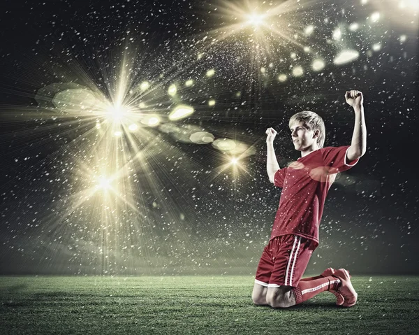 Jogador de futebol de pé de joelhos — Fotografia de Stock