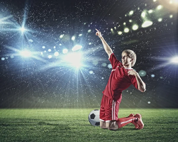 Jogador de futebol de pé de joelhos — Fotografia de Stock