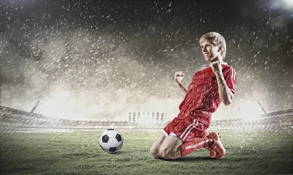 Jogador de futebol de pé de joelhos — Fotografia de Stock