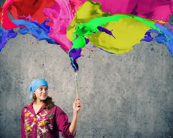 Painter with brush and colorful splashes — Stock Photo, Image