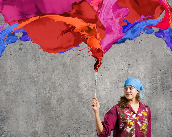 Painter with brush and colorful splashes — Stock Photo, Image