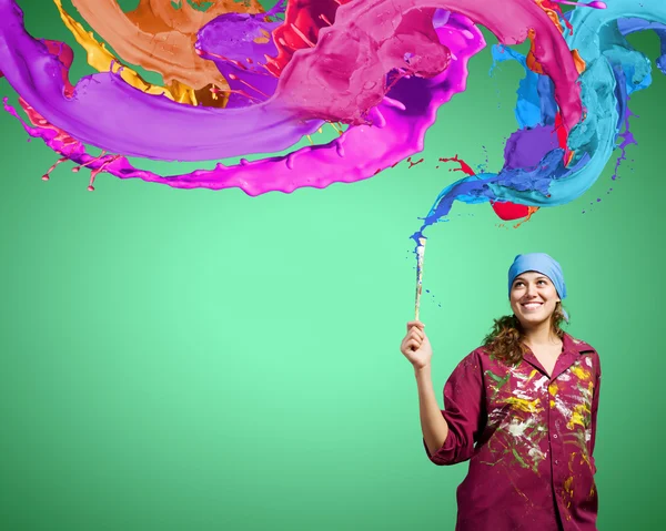 Painter with brush and colorful splashes — Stock Photo, Image