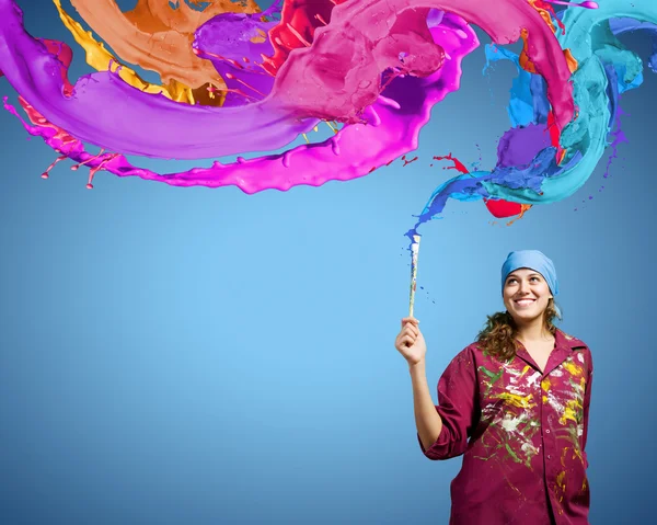 Painter with brush and colorful splashes — Stock Photo, Image