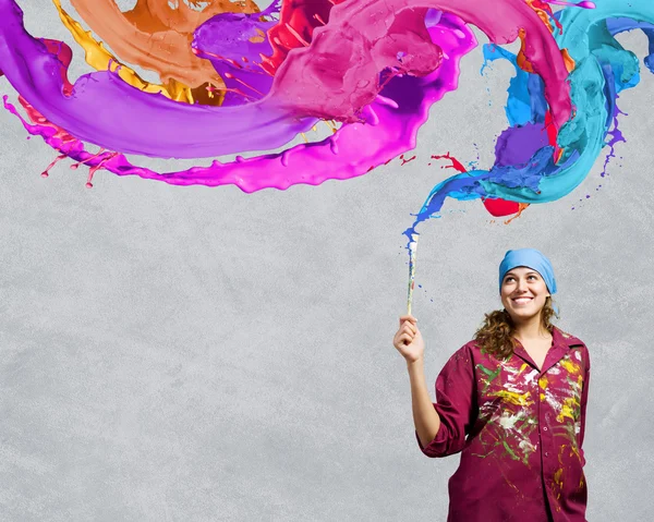 Painter with brush and colorful splashes — Stock Photo, Image