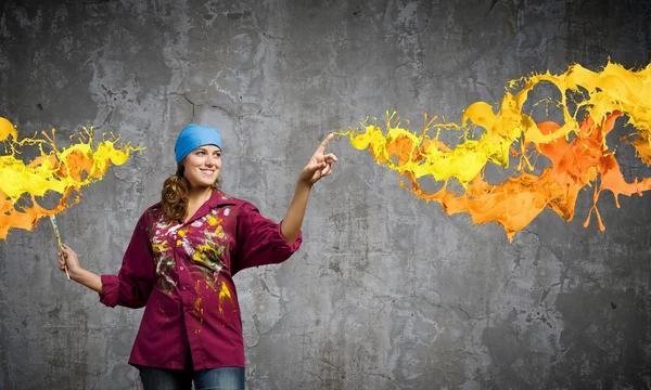 Painter with brush and colorful splashes — Stock Photo, Image