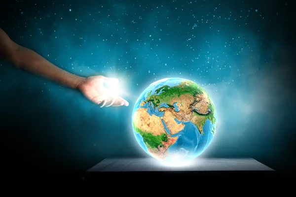 Рукою людини, торкаючись Землі планети пальцем Ліцензійні Стокові Зображення