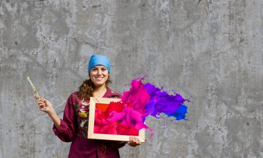 Painter holding frame with colorful splashes clipart
