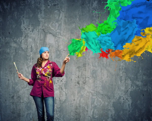 Painter with brush and colorful splashes — Stock Photo, Image