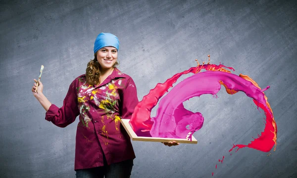 Painter holding frame with colorful splashes — Stock Photo, Image