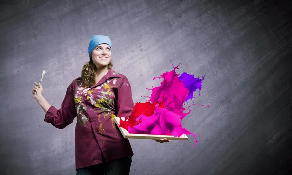 Painter holding frame with colorful splashes — Stock Photo, Image