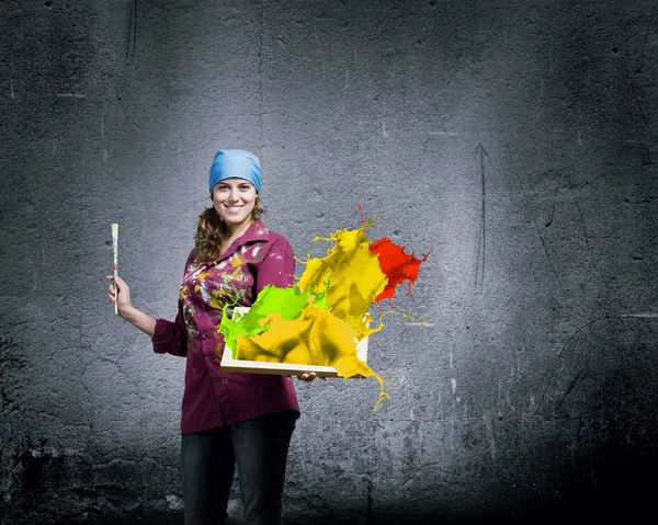 Painter holding frame with colorful splashes — Stock Photo, Image