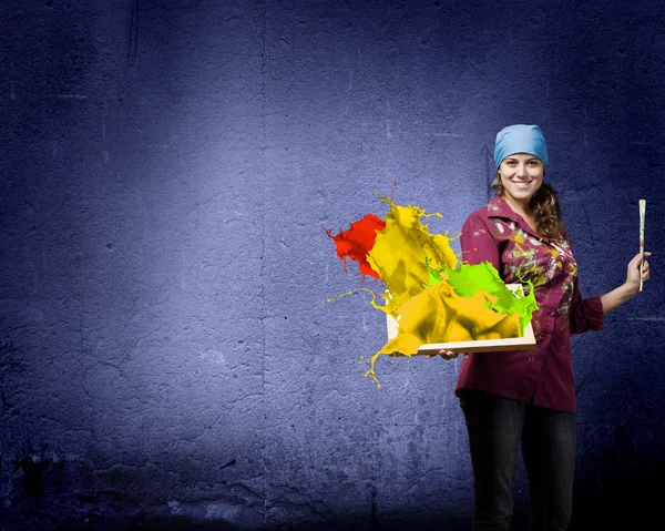 Painter holding frame with colorful splashes — Stock Photo, Image