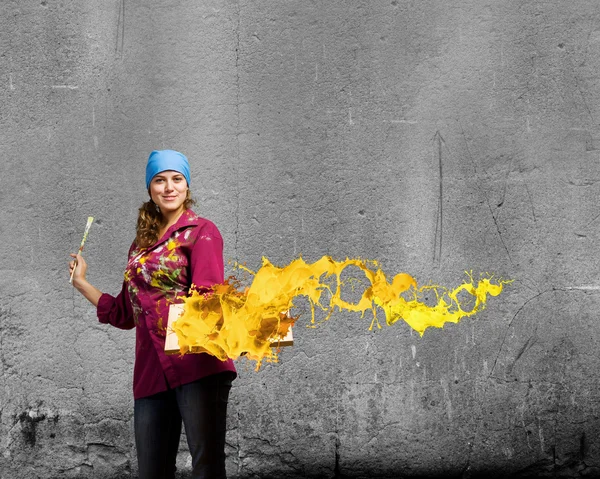 Painter holding frame with colorful splashes — Stock Photo, Image