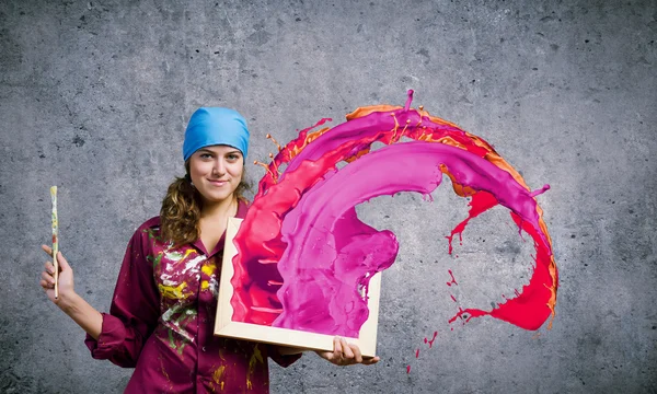 Painter holding frame with colorful splashes — Stock Photo, Image