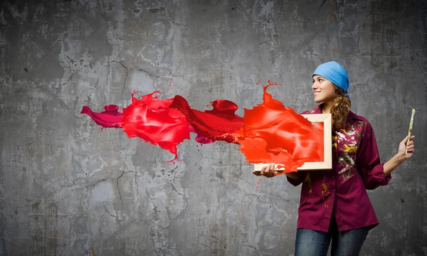Художник тримає рамку з різнокольоровими бризками — стокове фото