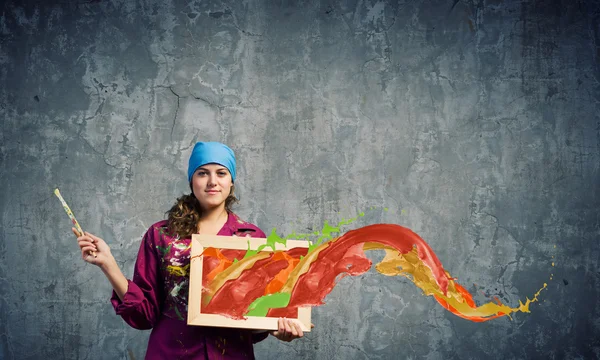 Maler hält Rahmen mit bunten Spritzern — Stockfoto