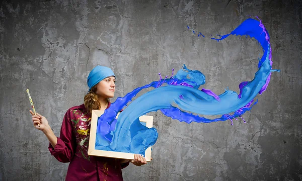 Maler hält Rahmen mit bunten Spritzern — Stockfoto