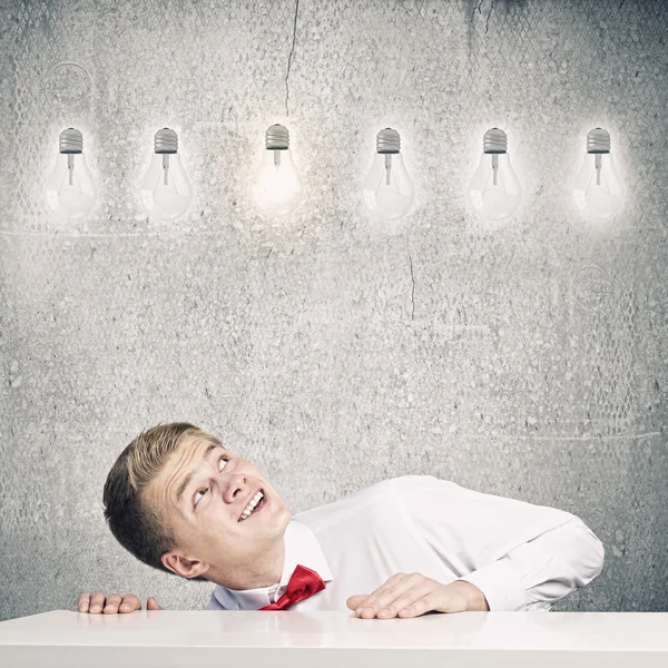 Man looking at light bulbs — Stock Photo, Image