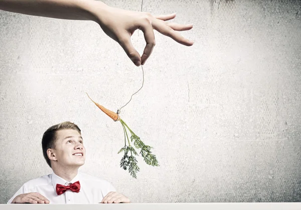 Человек, преследуемый морковью — стоковое фото
