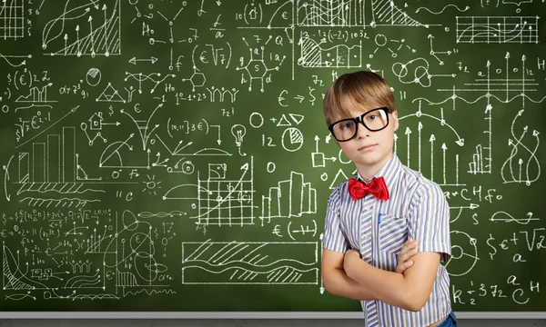 Niño genio cerca de pizarra con fórmulas —  Fotos de Stock