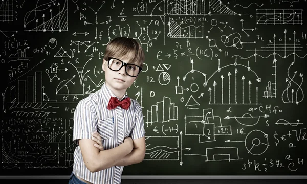 Niño genio cerca de pizarra con fórmulas — Foto de Stock