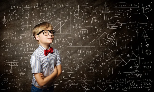 Genius boy near blackboard with formulas — Stock Photo, Image