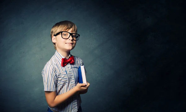 Smart schoolboy near blackboard — Stock Photo, Image