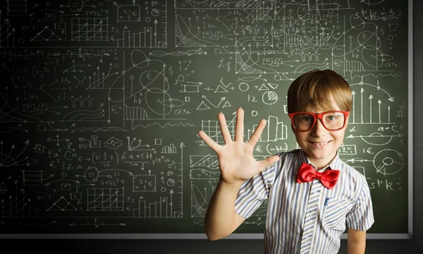 Niño genio cerca de pizarra con fórmulas — Foto de Stock