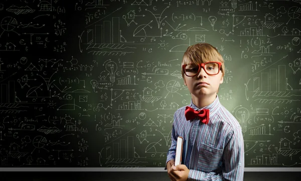 Genius boy near blackboard with formulas — Stock Photo, Image