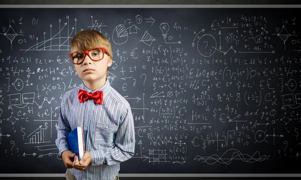 Genius boy near blackboard with formulas — Stock Photo, Image