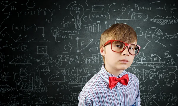 Niño genio cerca de pizarra con fórmulas — Foto de Stock