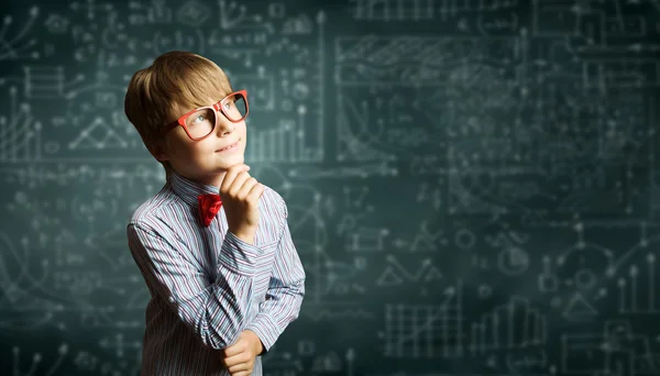 Niño genio cerca de pizarra con fórmulas — Foto de Stock