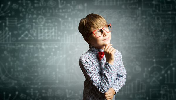 Genius boy near blackboard with formulas