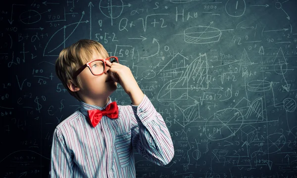 Génie garçon près de tableau noir avec des formules — Photo