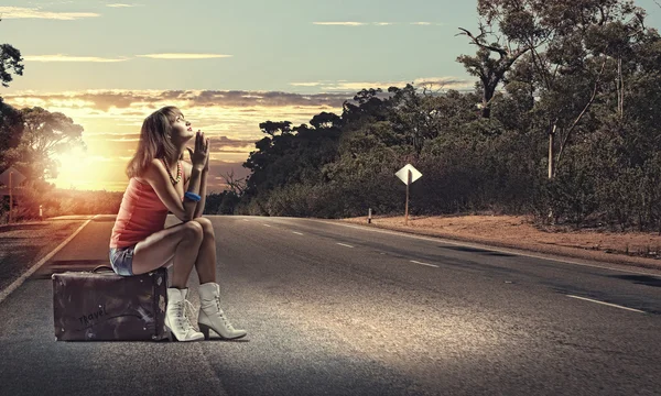 Girl traveler sitting on suitcase — Stock Photo, Image