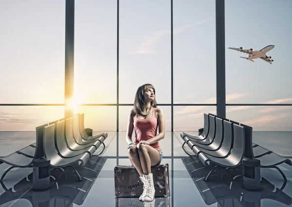 Viajero en el aeropuerto sentado en la maleta — Foto de Stock