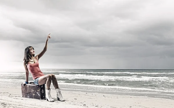 Toeristische zittend op koffer aan zee — Stockfoto